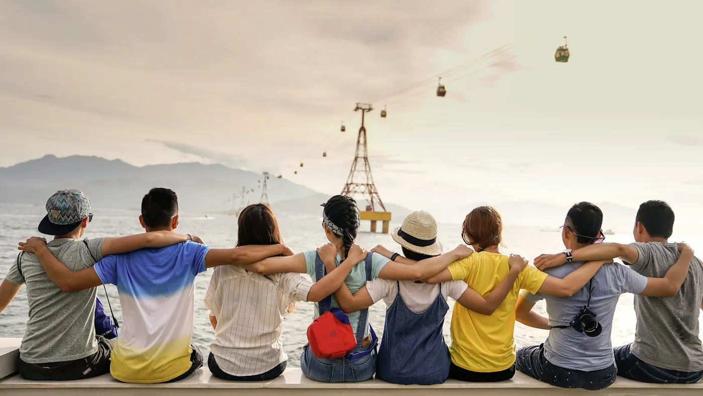 Grupo de amigos abrazados frente al mar